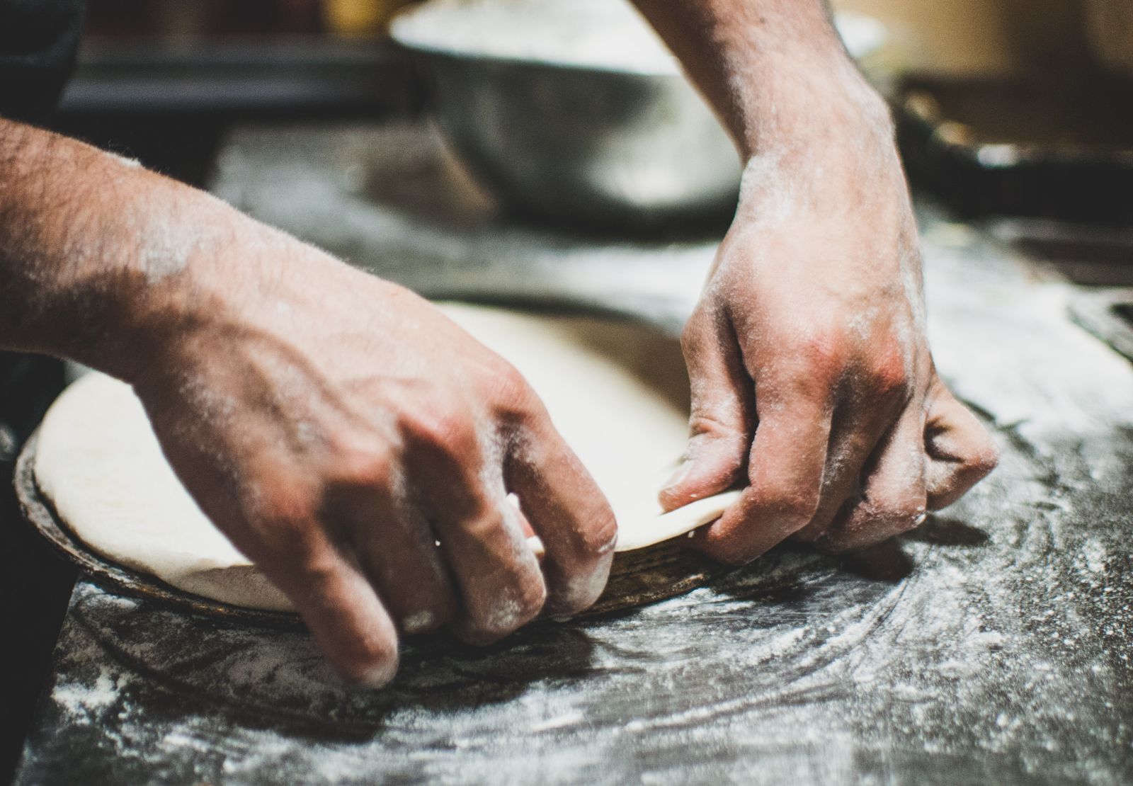 Flour-dusted hands kneading dough